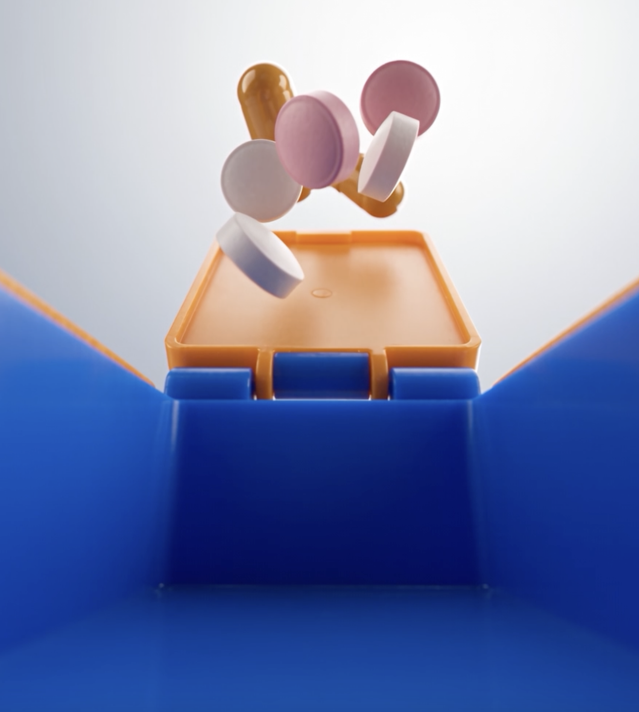 Medication being placed into an open organizer compartment
